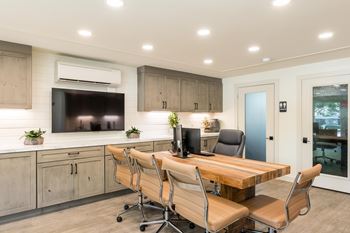 A modern kitchen with a wooden table and chairs.